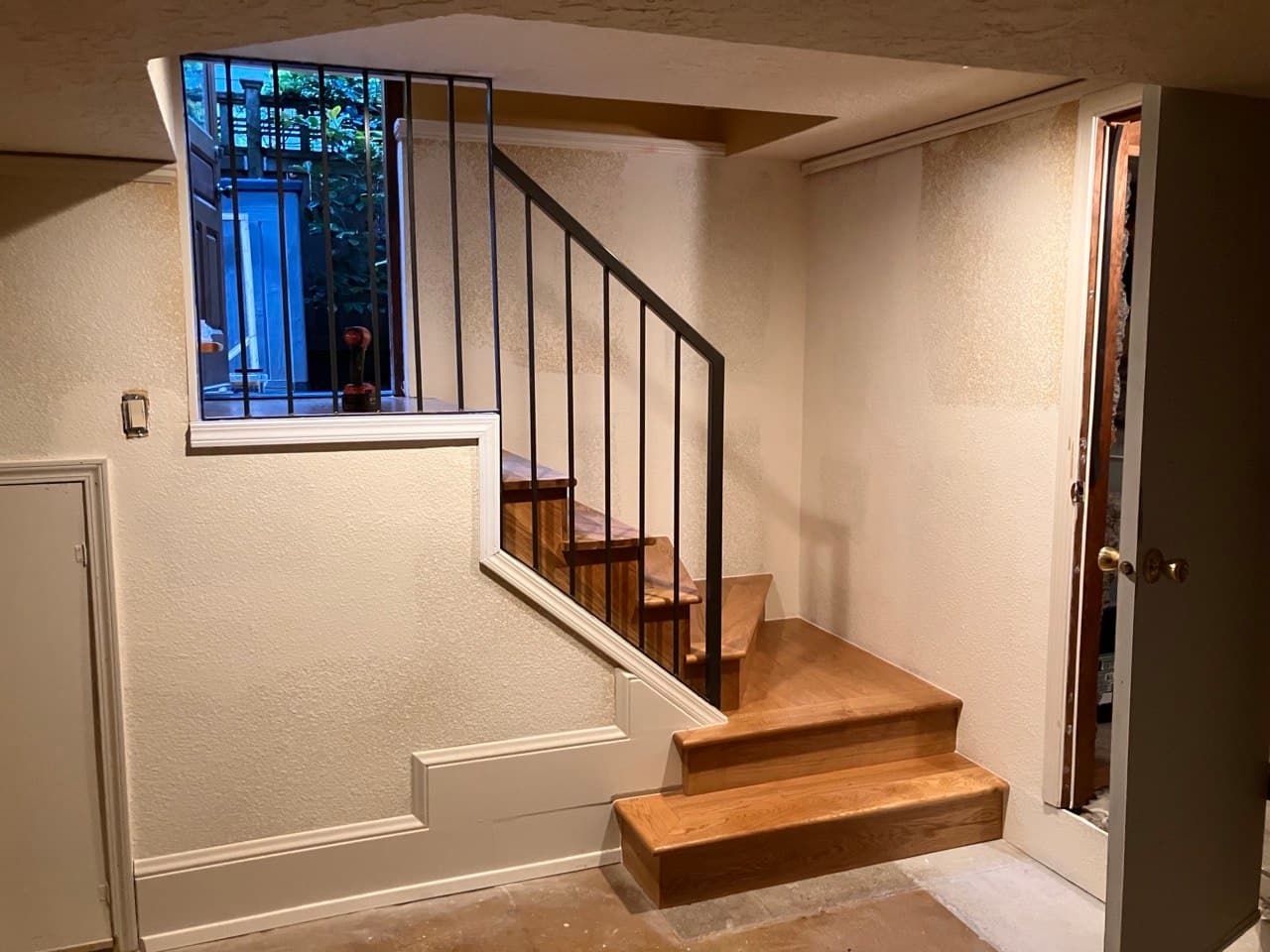 Custom L-shaped white oak staircase with black steel railing — basement entry build by Stumptown Stairs, Portland, OR
