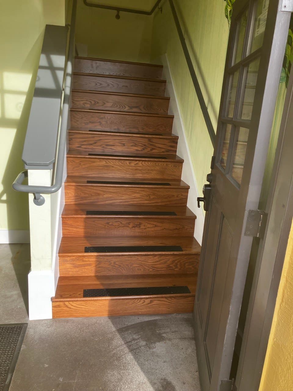 Repaired staircase with refinished oak treads and new traction strips — Stumptown Stairs, Portland, OR